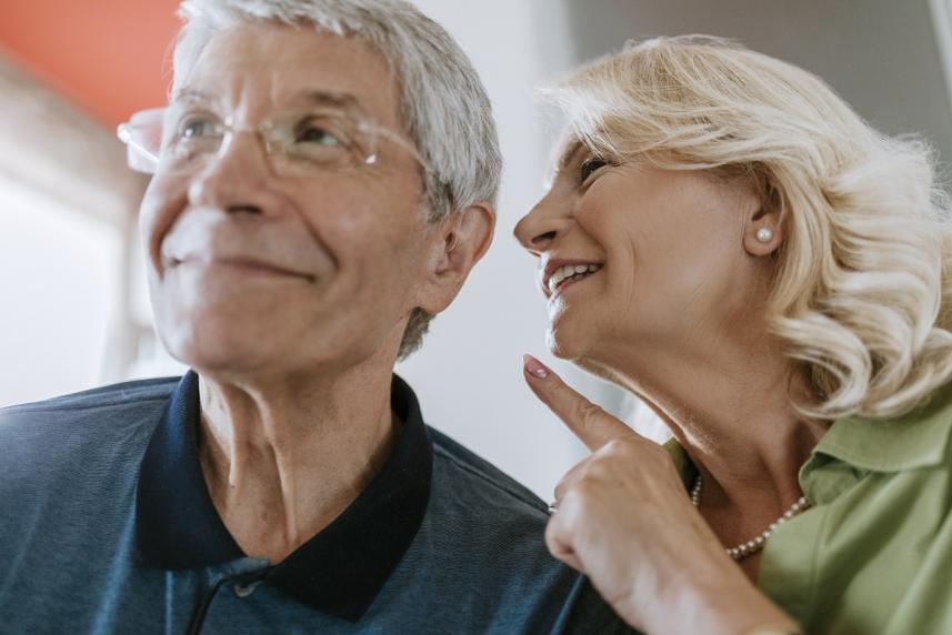 Woman talking into her husband's ear