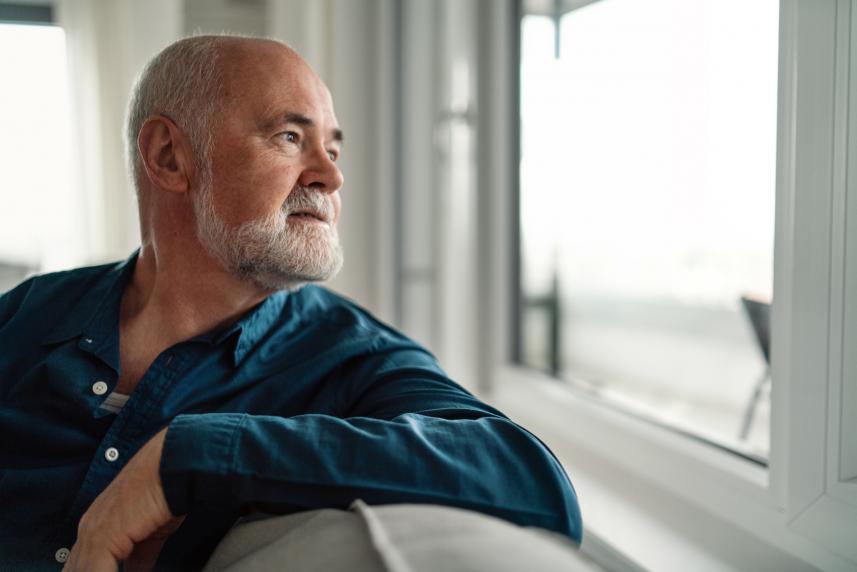 A man looks pensively out the window.