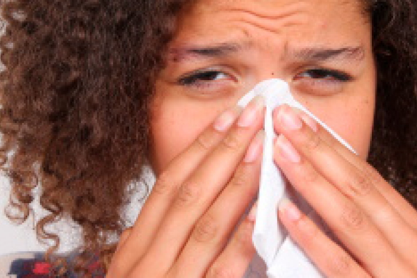Photo: Young woman blowing nose