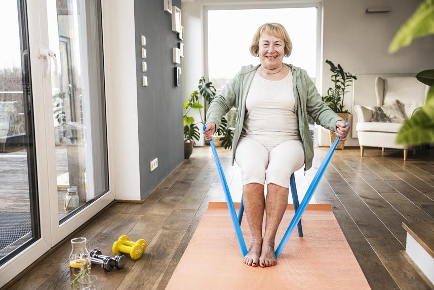 A woman sitting and using a resistance band to stretch