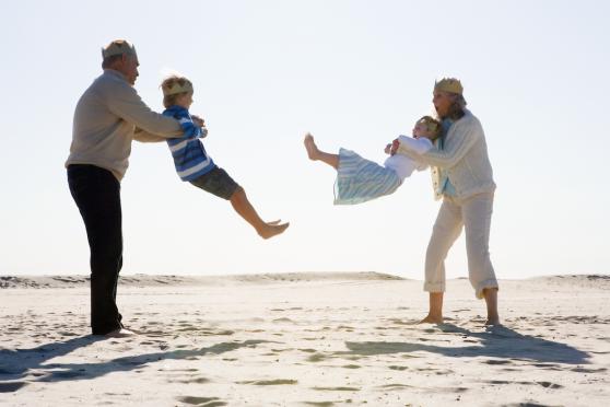 Grandparents playing with grandchildren on beach